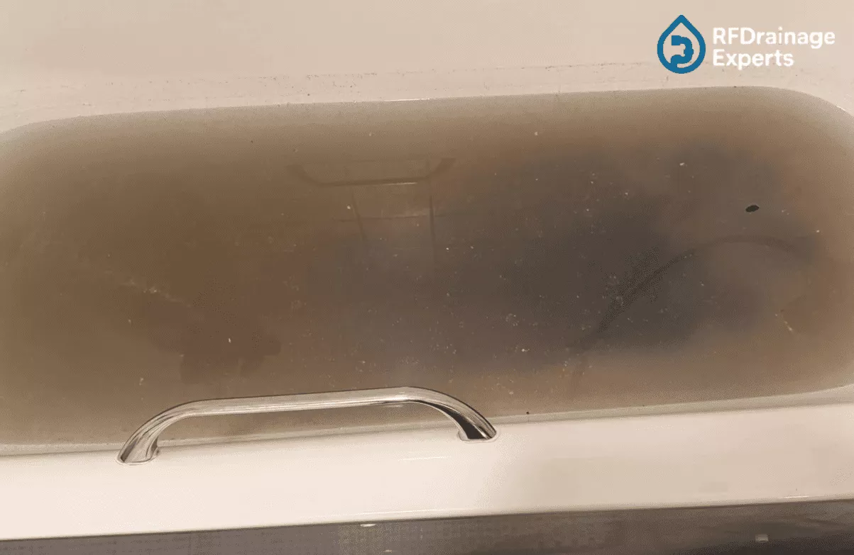 Professional plumber checking pipes to Clean Kitchen Drains in London home kitchen